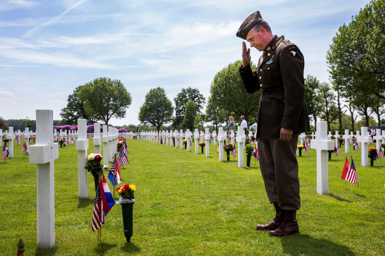 Dutch Eric Ommering, wearing a WWII uniform, salutes at a grave he adopted of Sergeant Charles Mc Millan, 315 Infantry 79 Division, from Michigan, during a Memorial Day commemoration service