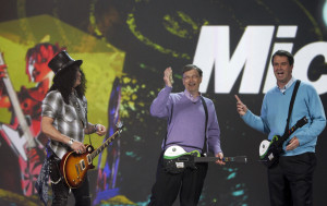 Microsoft Chairman Bill Gates (C) holds up twenty dollars he won from Robbie Bach (R), President of the company's Entertainment and Devices Division, as guitarist Slash  (L) joins them in a "Guitar Hero" match durling the keynote address at the 2008 Consumer Electronics Show in Las Vegas, Nevada January 6, 2008. It was GatesÕ tenth and final CES keynote address.  Photo by Lee Celano/Microsoft Corp.